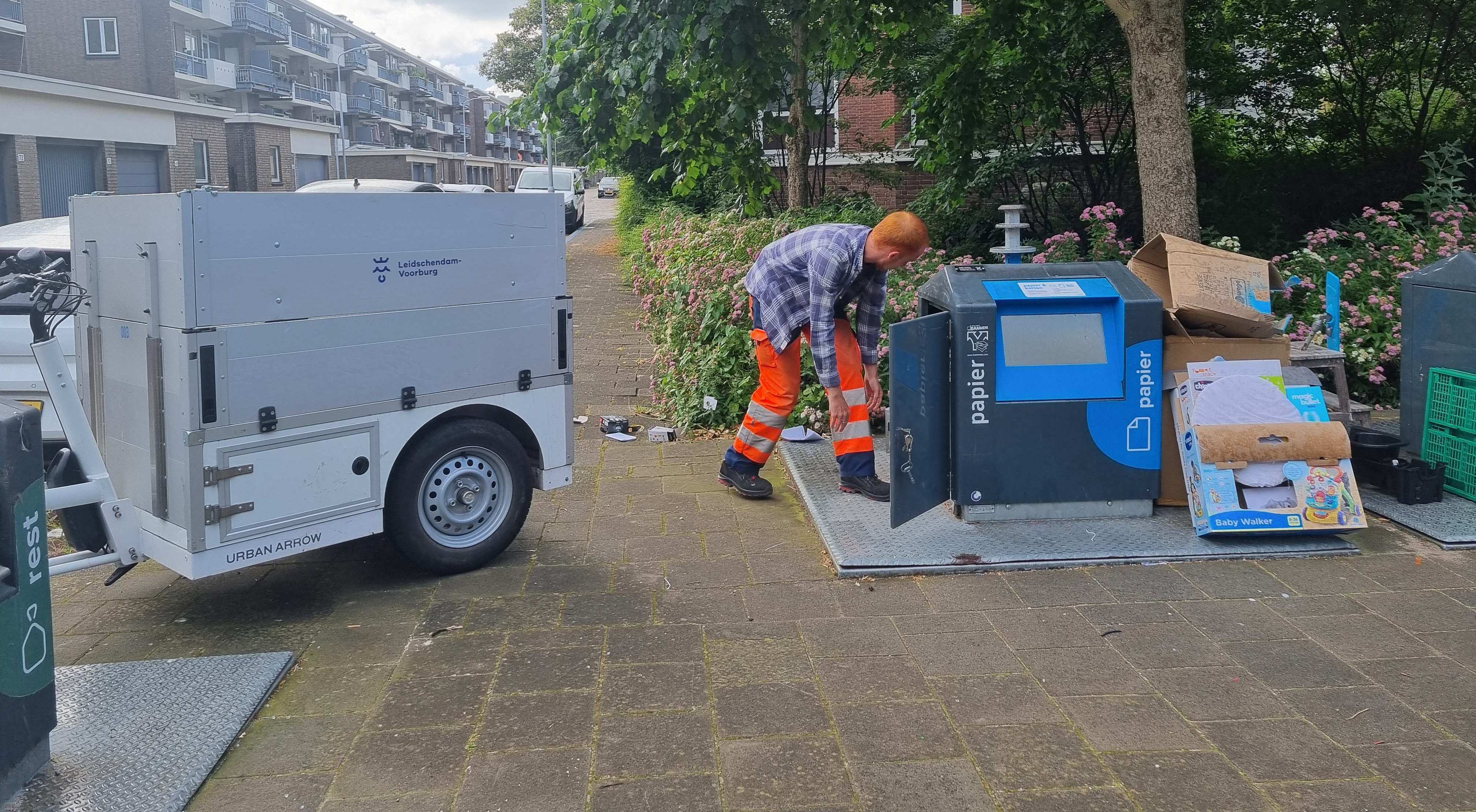 Medewerkers van  de gemeente maakt papiercontainer  weer bruikbaar 3